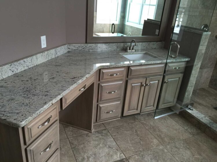 Bathroom remodel with an L-shaped granite vanity and custom cabinets in Canfield, OH